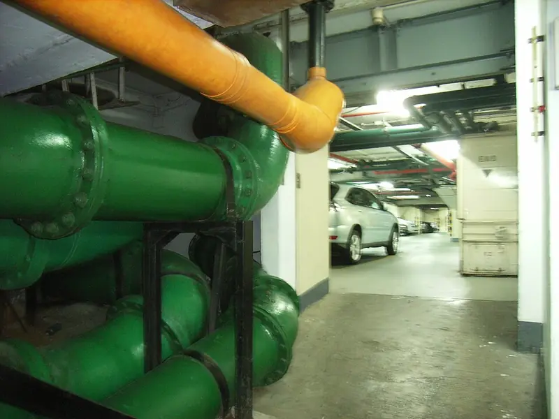 Tubulações verdes com suportes em garagem