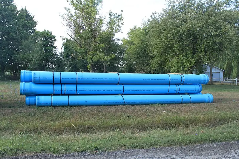 Tubos de PVC azuis para água sobre o gramado