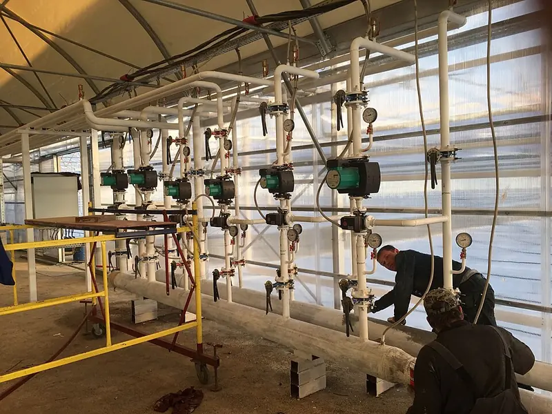 Barrilete com bombas e válvulas em estufa agrícola