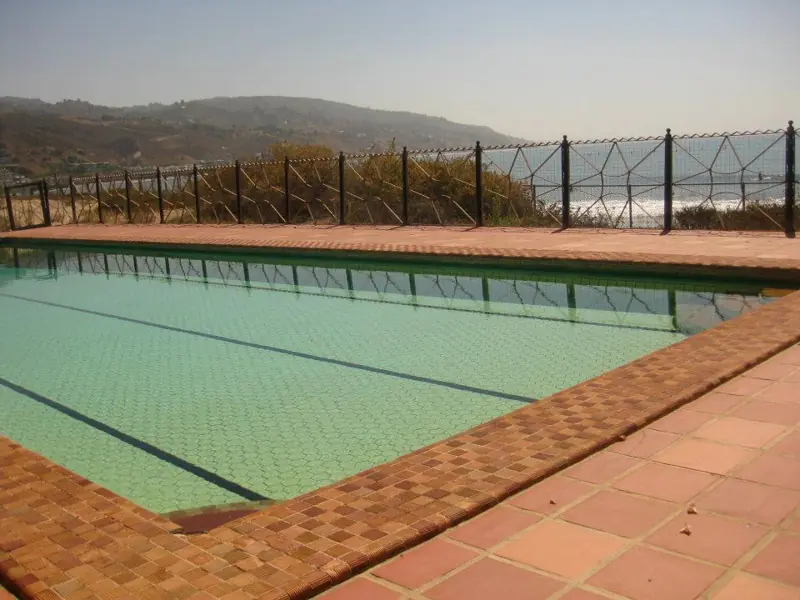 Piscina externa com borda e área de deck