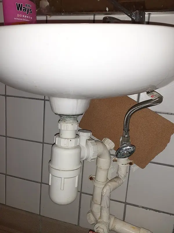 Sifão e ligação de esgoto sob um lavatório